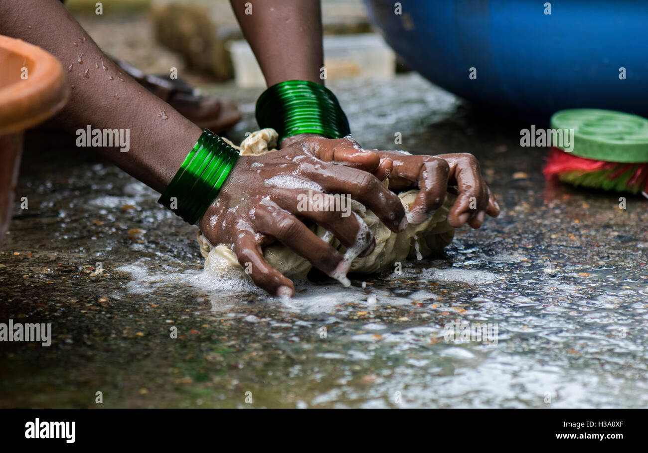 Eine Dame hart daran gearbeitet, die Wäsche für ihre Familie im Garten ihres Hauses in einem kleinen Weiler in Tillari, Dodamarg, Maharasht Stockfoto