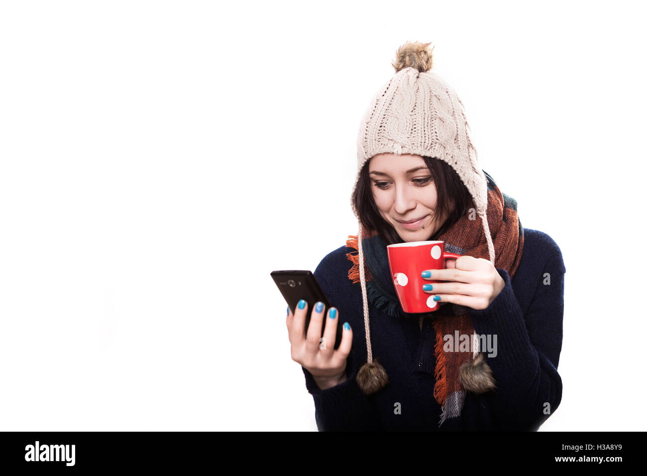 attraktives Mädchen riecht ihr heiße Suppe im Winter während des Tragens einer festlichen farbige Strickjacke Stockfoto