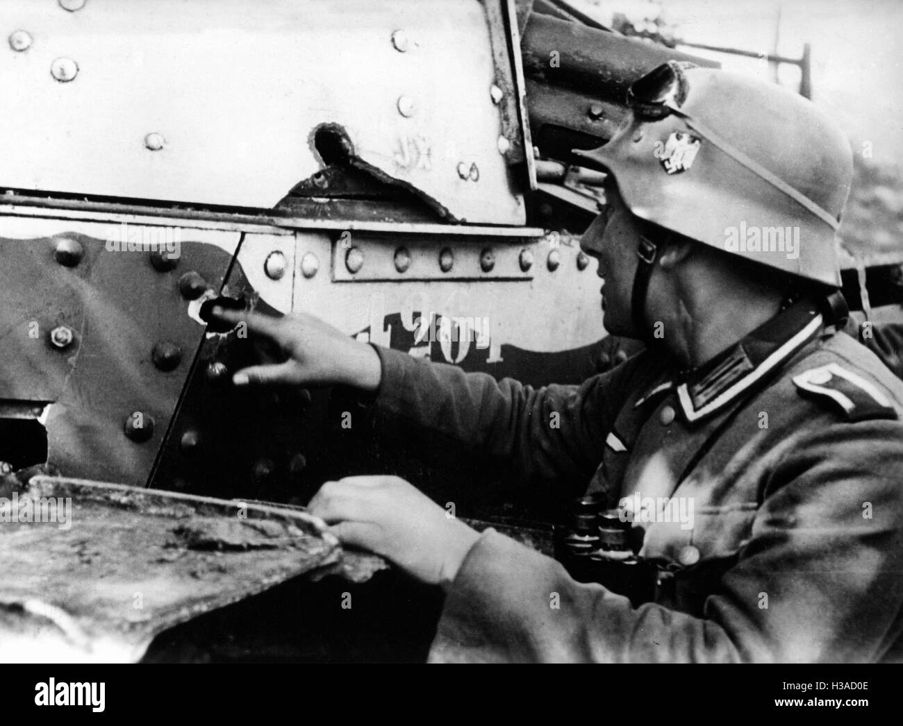 Deutscher Soldat inspiziert einen beschädigten Tank in Frankreich, 1940 Stockfoto