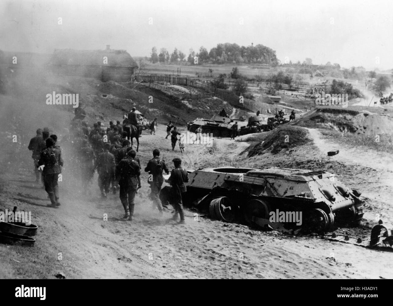 Deutsche Infanteristen gehen vorbei an abgeschossenen Panzer 1941 Stockfoto