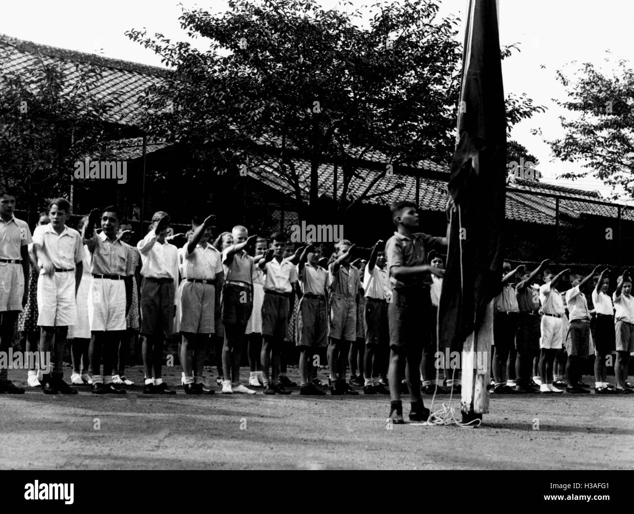 HJ-Mitglieder hissen Hakenkreuzfahne in Tokio, 1939 Stockfoto