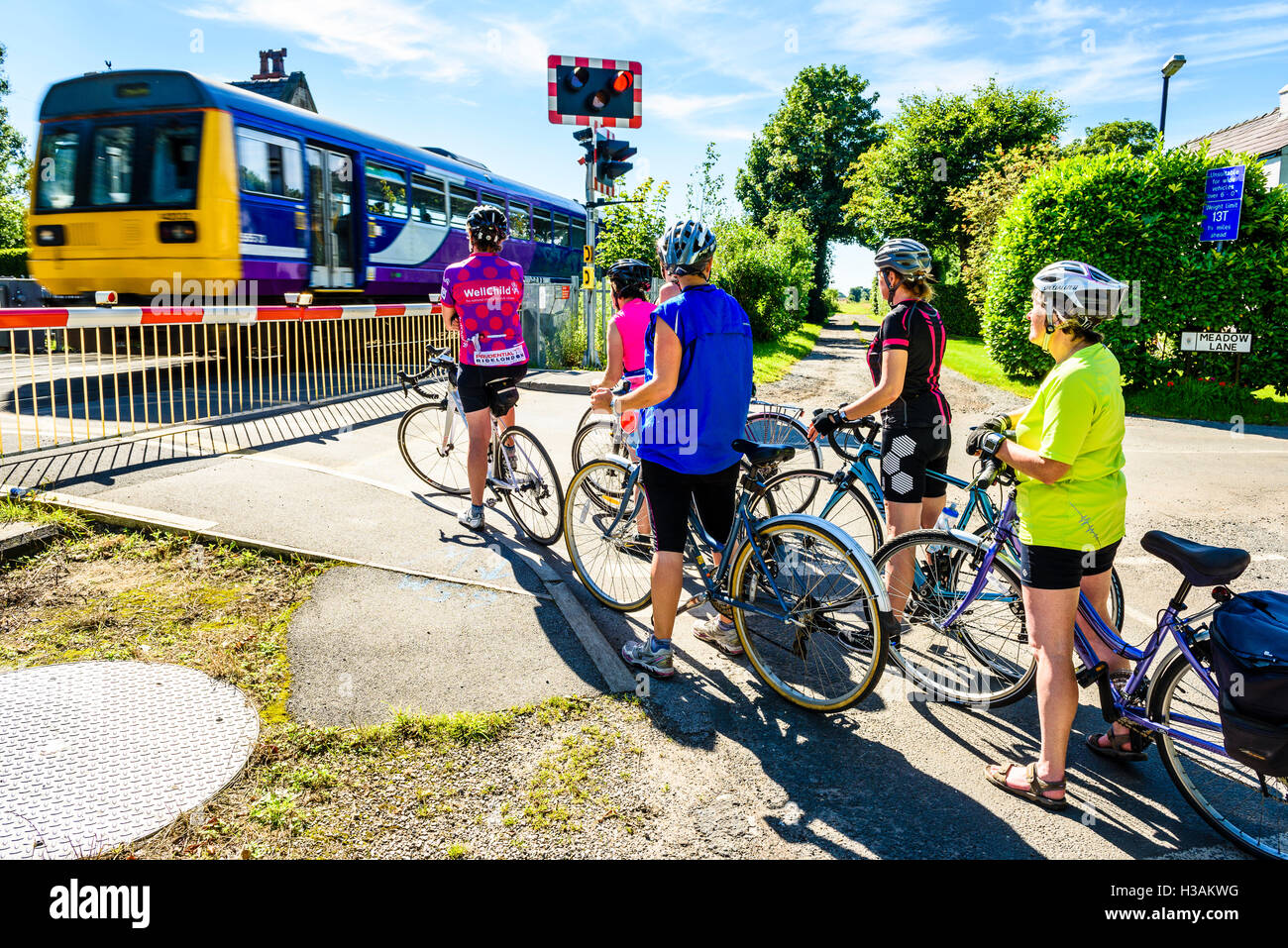 Gruppe von weiblichen Radfahrer warten am Bahnübergang in der Nähe von Burscough in West Lancashire England UK Stockfoto