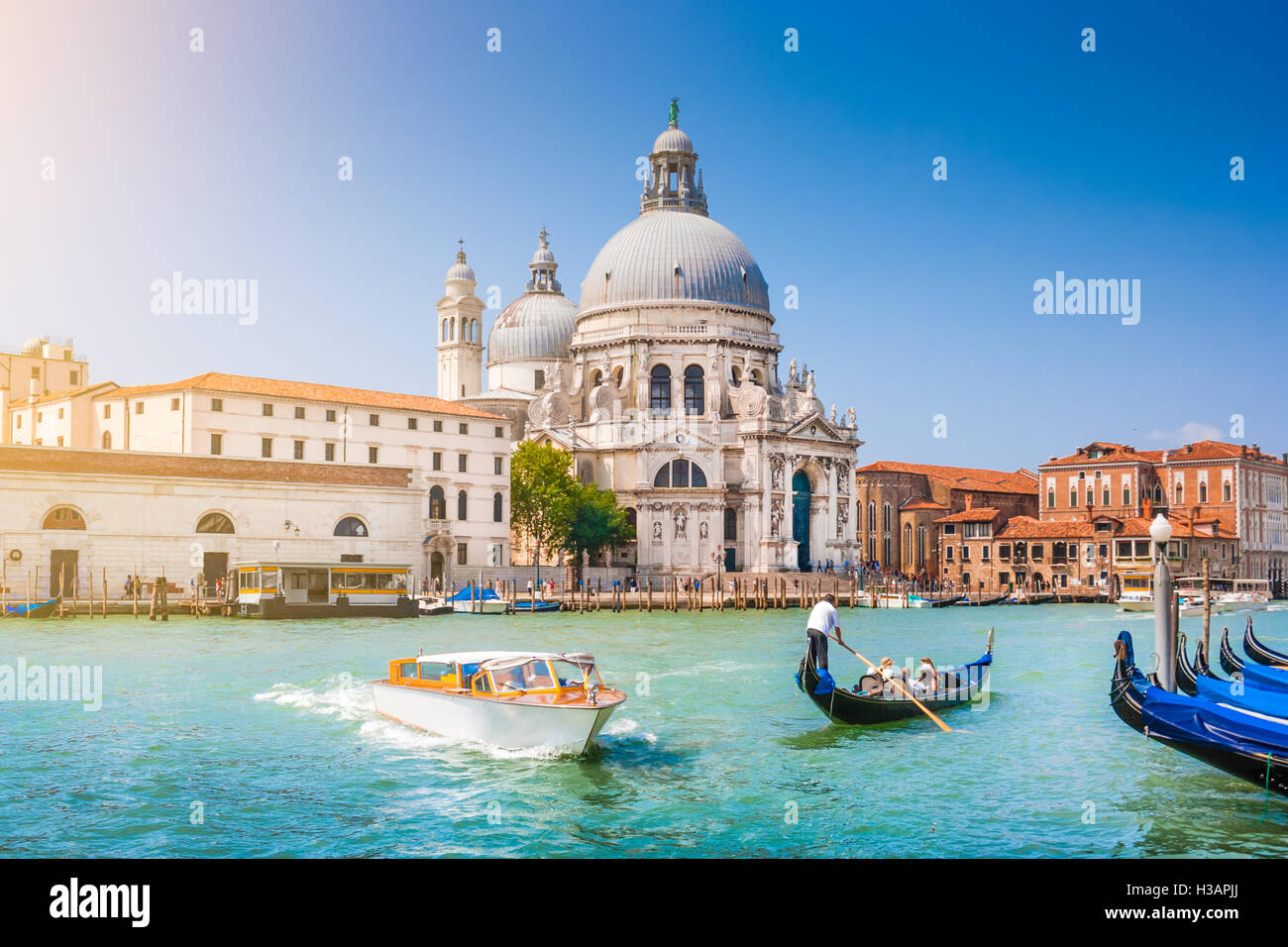 Traditionelle Gondel und Boot am Canal Grande mit historischen Basilika di Santa Maria della Salute im Hintergrund, Venedig, Italien Stockfoto
