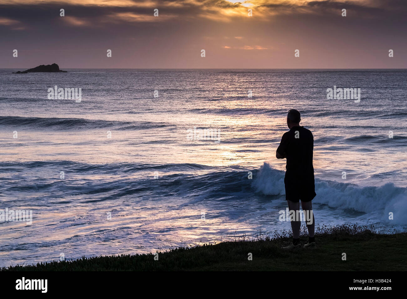 Die Silhouette eines Mannes stehend mit Blick auf Fistral Nord in Newquay, Cornwall. Stockfoto