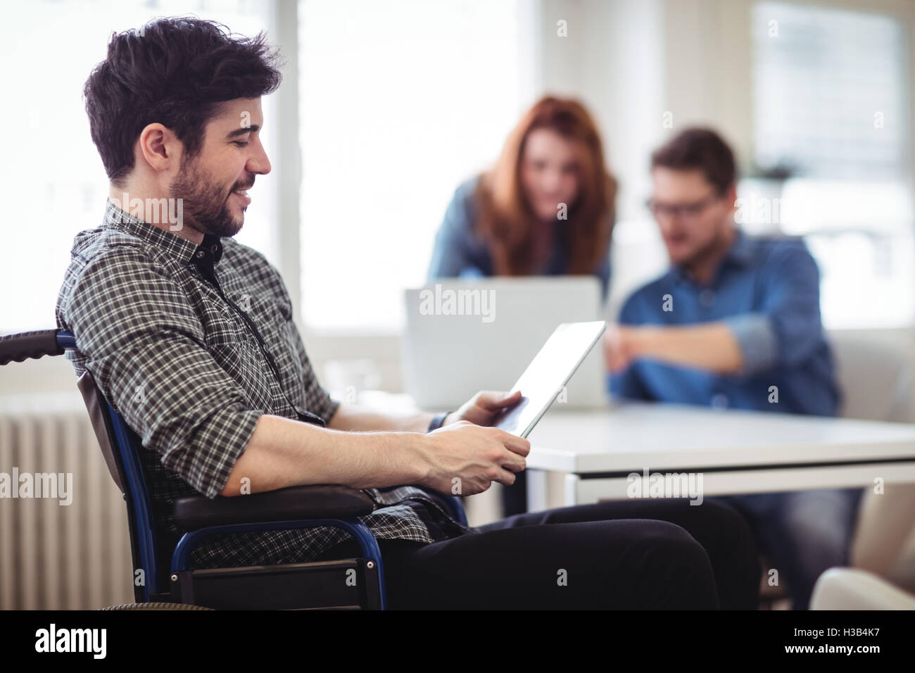 Geschäftsmann am Rollstuhl mit digital-Tablette Stockfoto