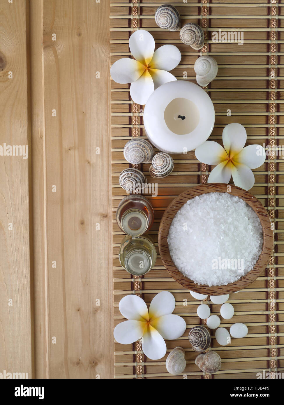 Muscheln, massage-Öle und Tiare Blüten auf dem hölzernen Hintergrund Stockfoto