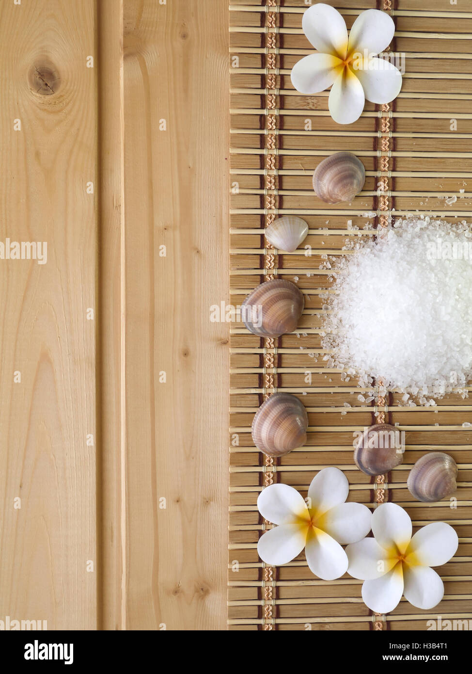 Muscheln und Tiare Blüten auf dem hölzernen Hintergrund Stockfoto