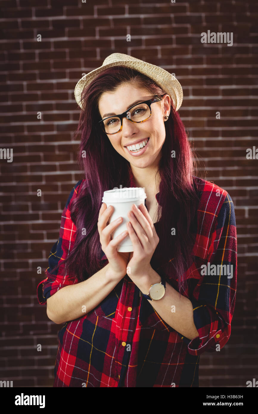 Junge Frau hält einen Kaffee Stockfoto