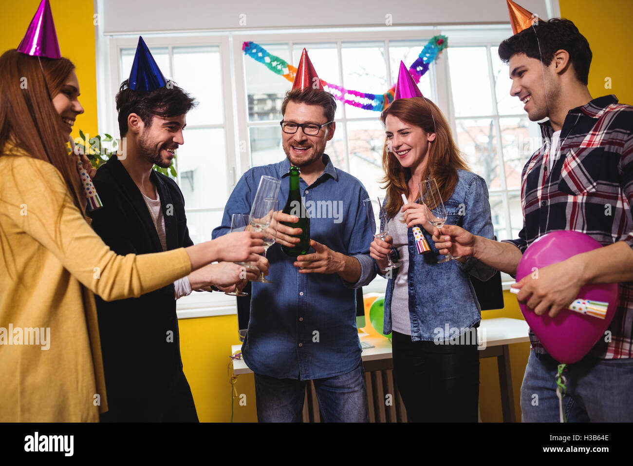Geschäftsleute, die mit Champagner während der Geburtstagsfeier Stockfoto