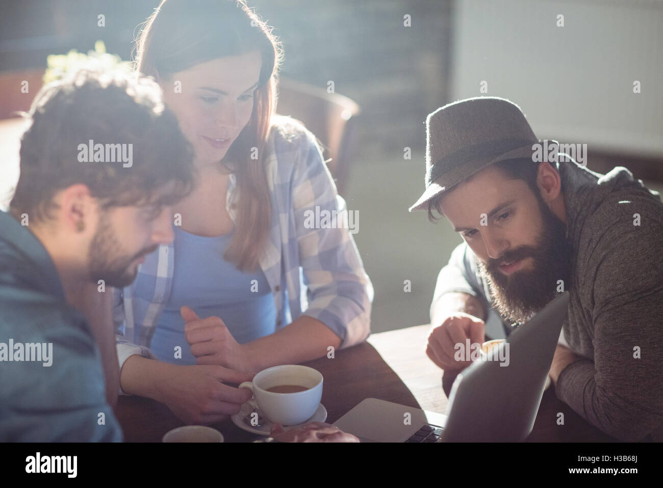 Junge Kunden betrachten Laptop im café Stockfoto