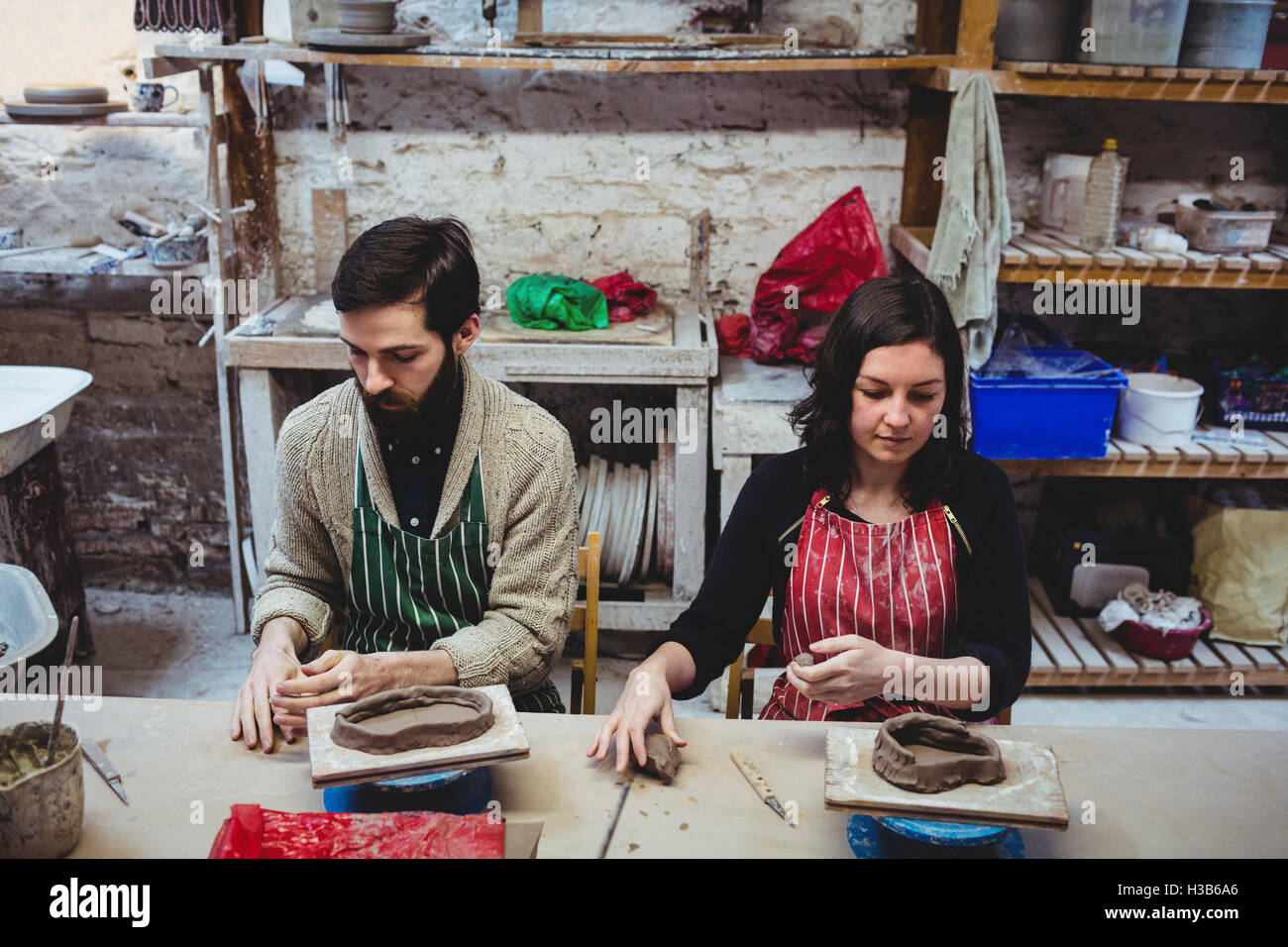 Männliche Potter mit Kollegin arbeiten am Tisch Stockfoto