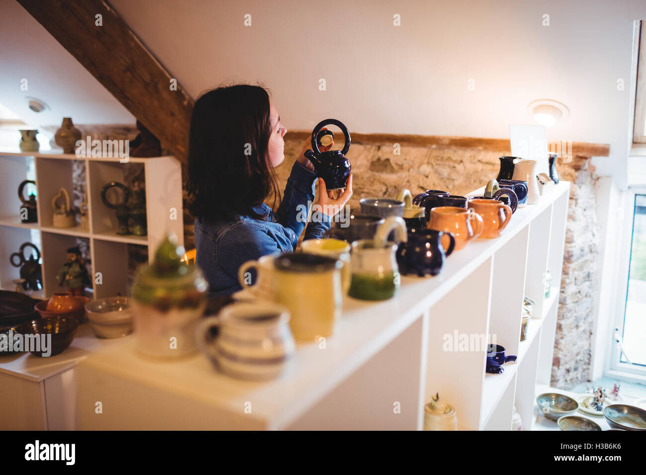 Weibliche Verbraucher halten Container im Keramik Shop Stockfoto