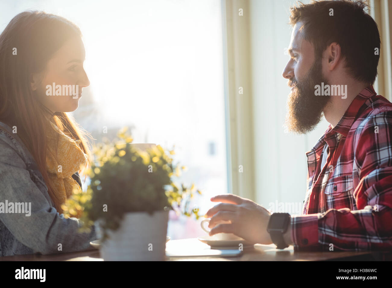 Seitenansicht von Mann und Frau sprechen im café Stockfoto