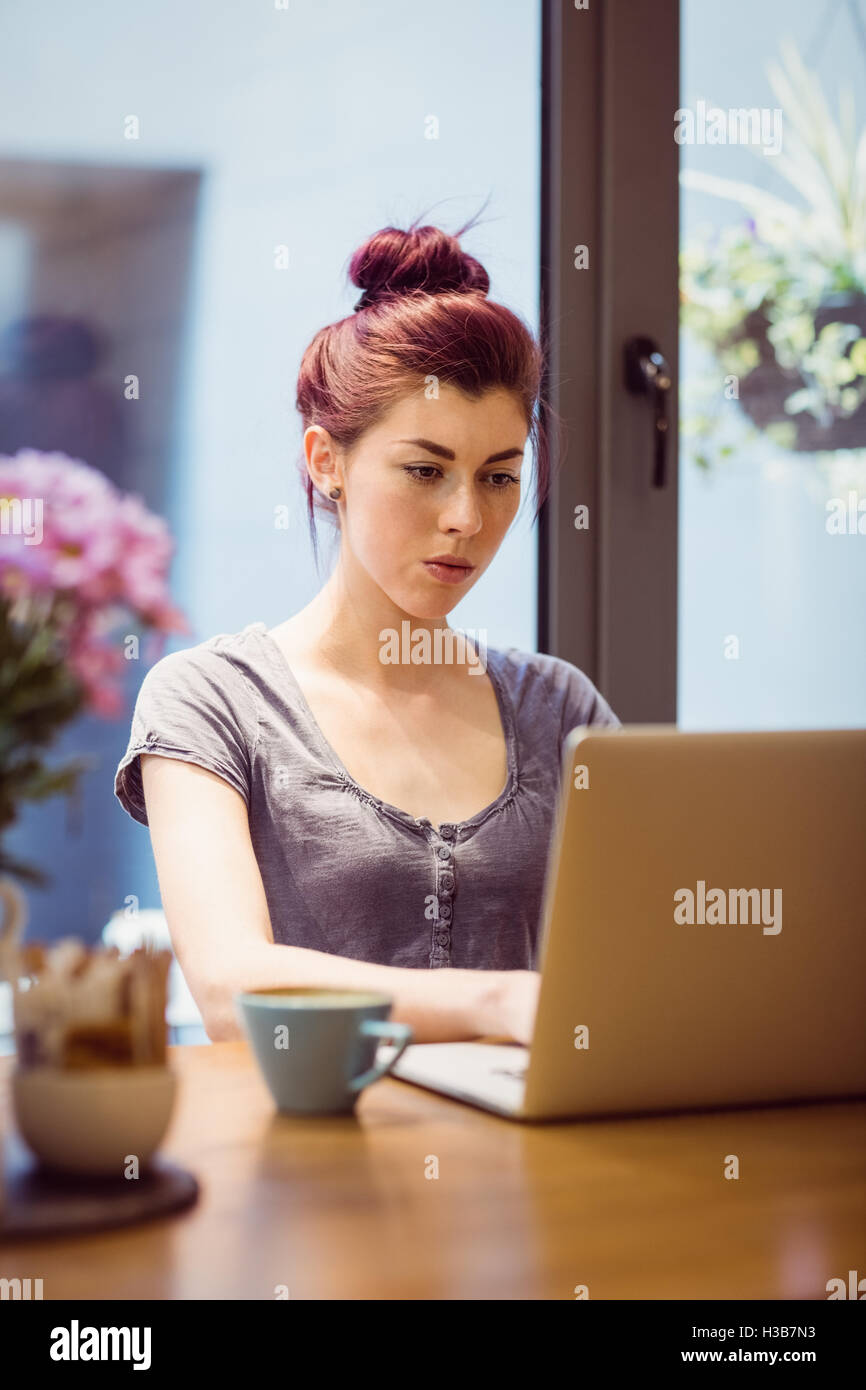 Hipster, trinken eine Tasse Kaffee, während mit einem laptop Stockfoto