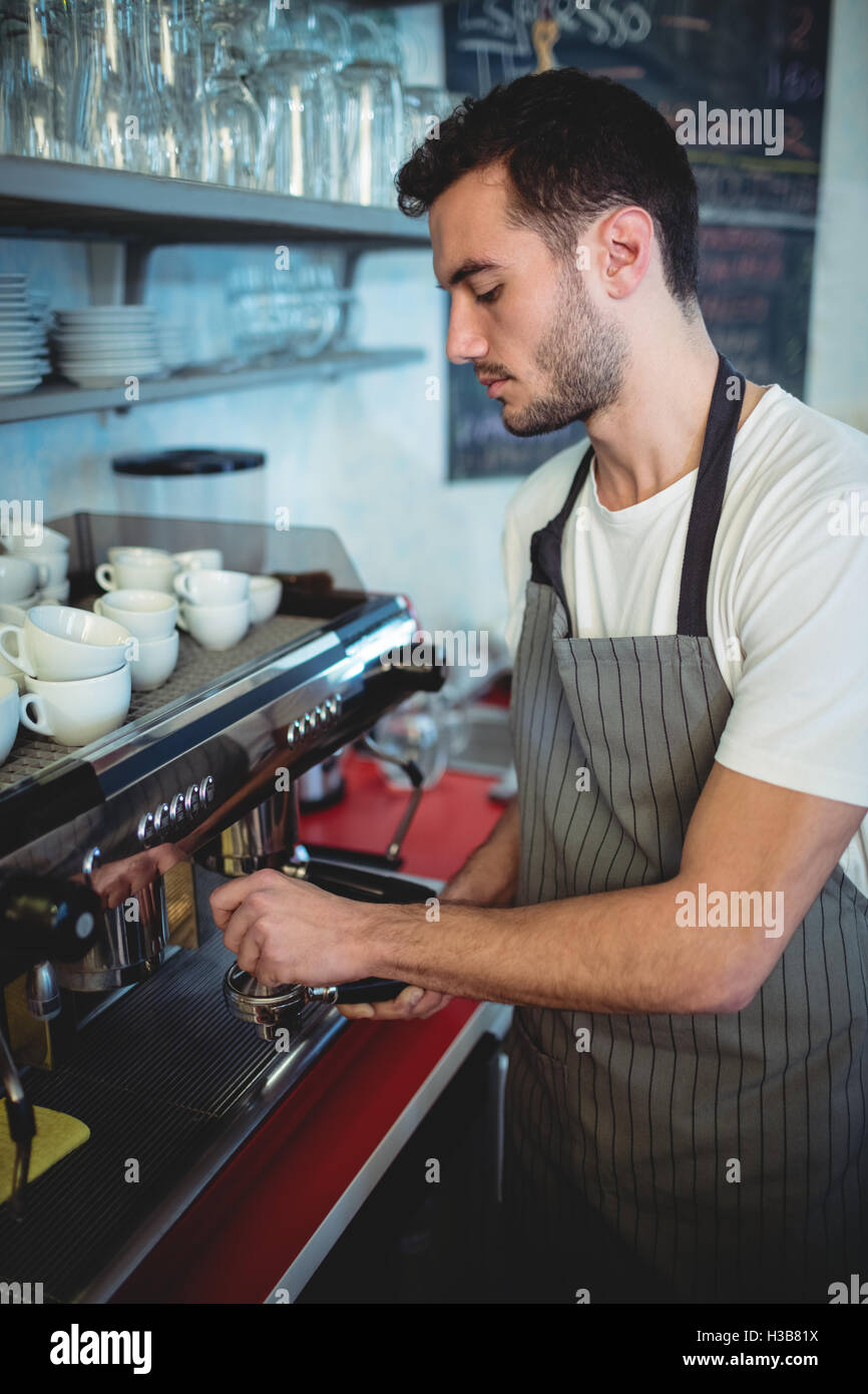 Hübscher Kellner mit Espresso Maker im café Stockfoto