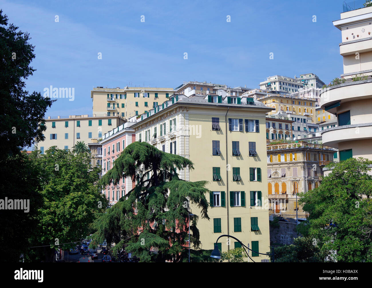 Apartment Gebäude in einer Vielzahl von Pastellfarben gestrichen, die eng an steilen Tal Seiten in einem Marktgebiet der Stadt Genua gestapelt. Stockfoto