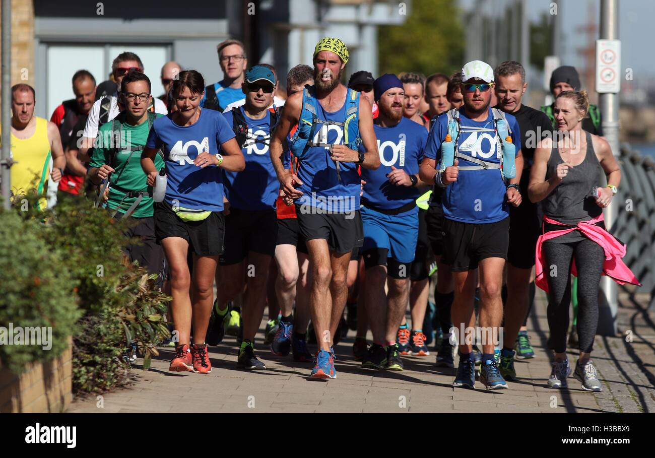 Ben Smith (Mitte) durchzieht Portishead Marina während der letzten Etappe von seinem 401. Marathon lief über 401 Tage. Stockfoto