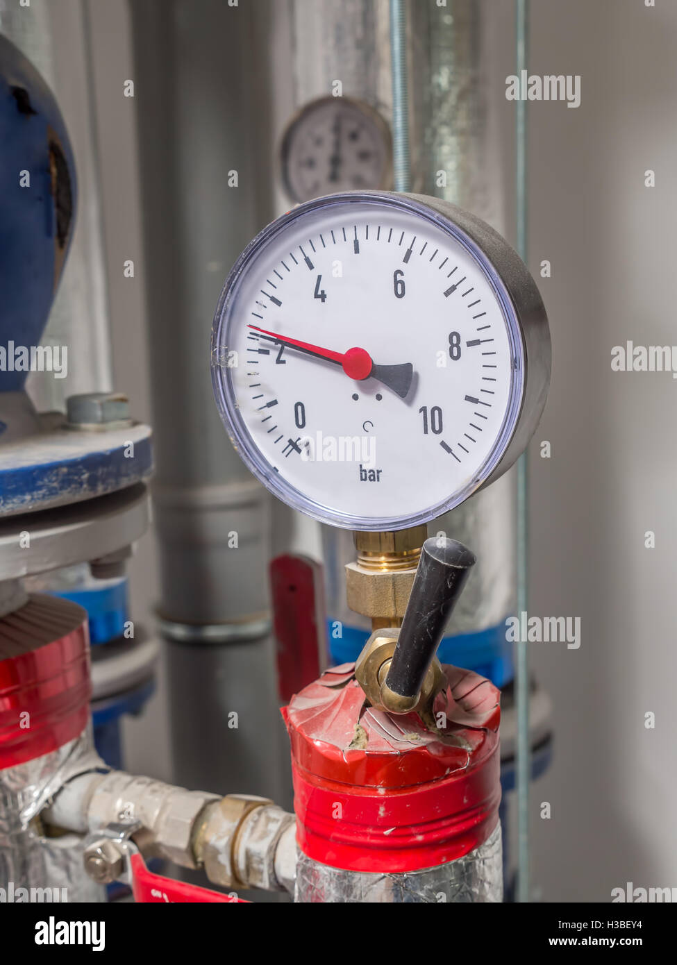 Wasserventil mit Manometer im Heizungsraum montiert Stockfoto