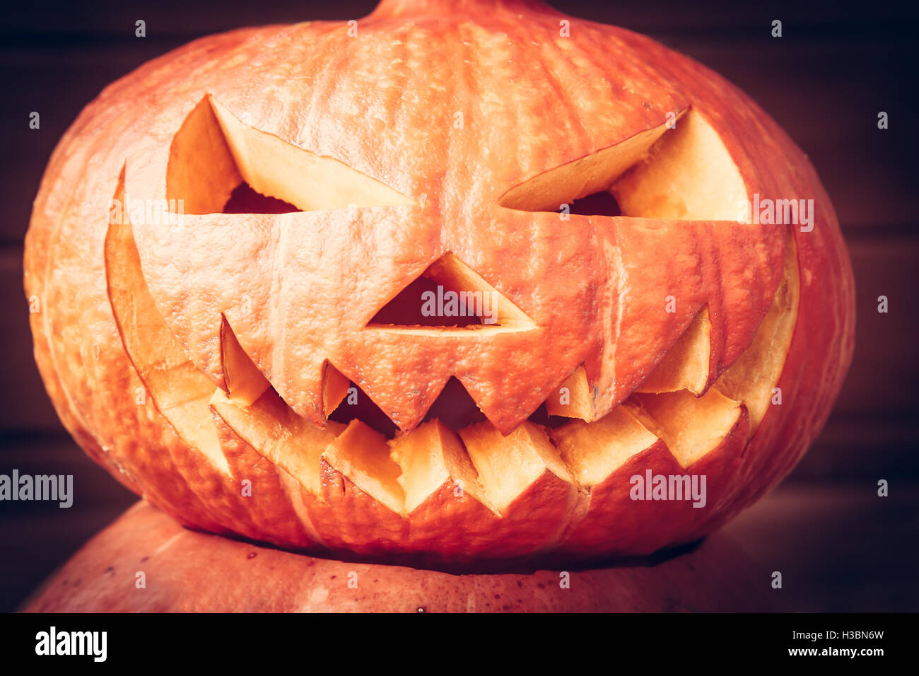Gruselige Halloween-Kürbis-Gesicht auf dunklem Hintergrund Stockfoto