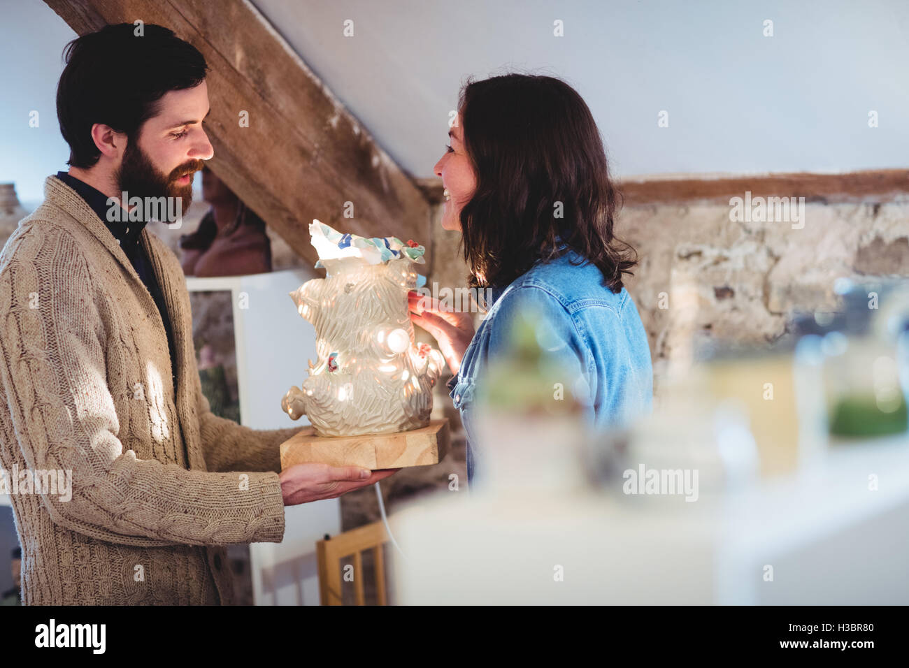 Männliche Potter hält Kunst Dekor mit Kollegen Stockfoto