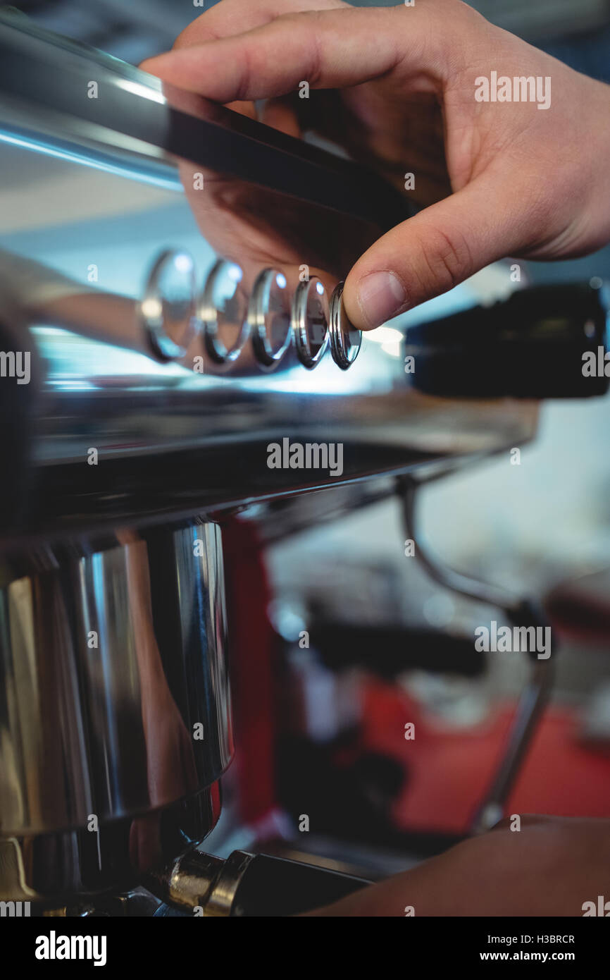 Zugeschnittenes Bild des Arbeiters Maschine Taste im café Stockfoto