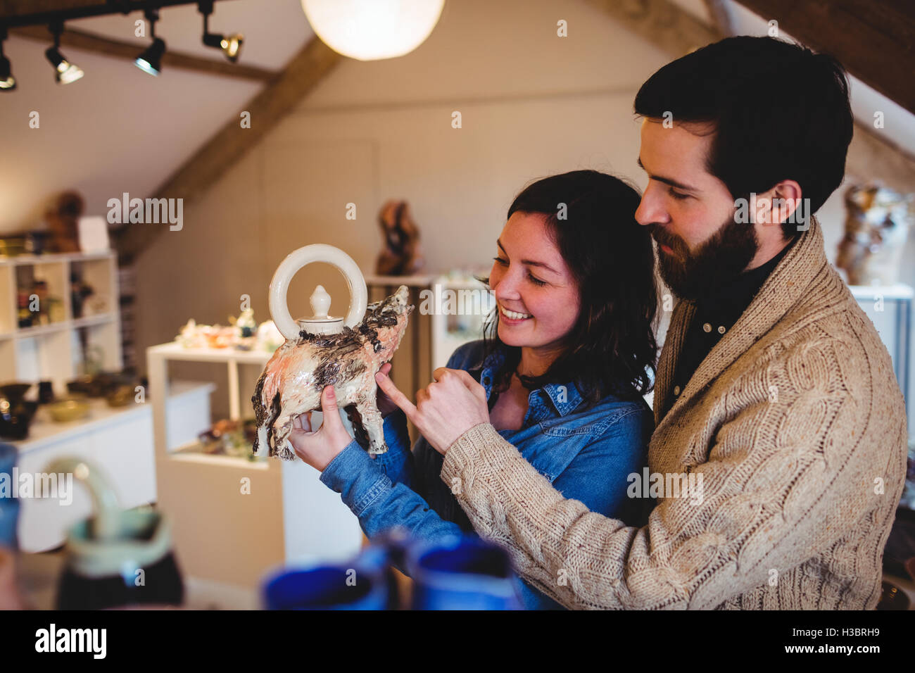 Lächelnde Käufer mit Figur im Keramik Shop Stockfoto