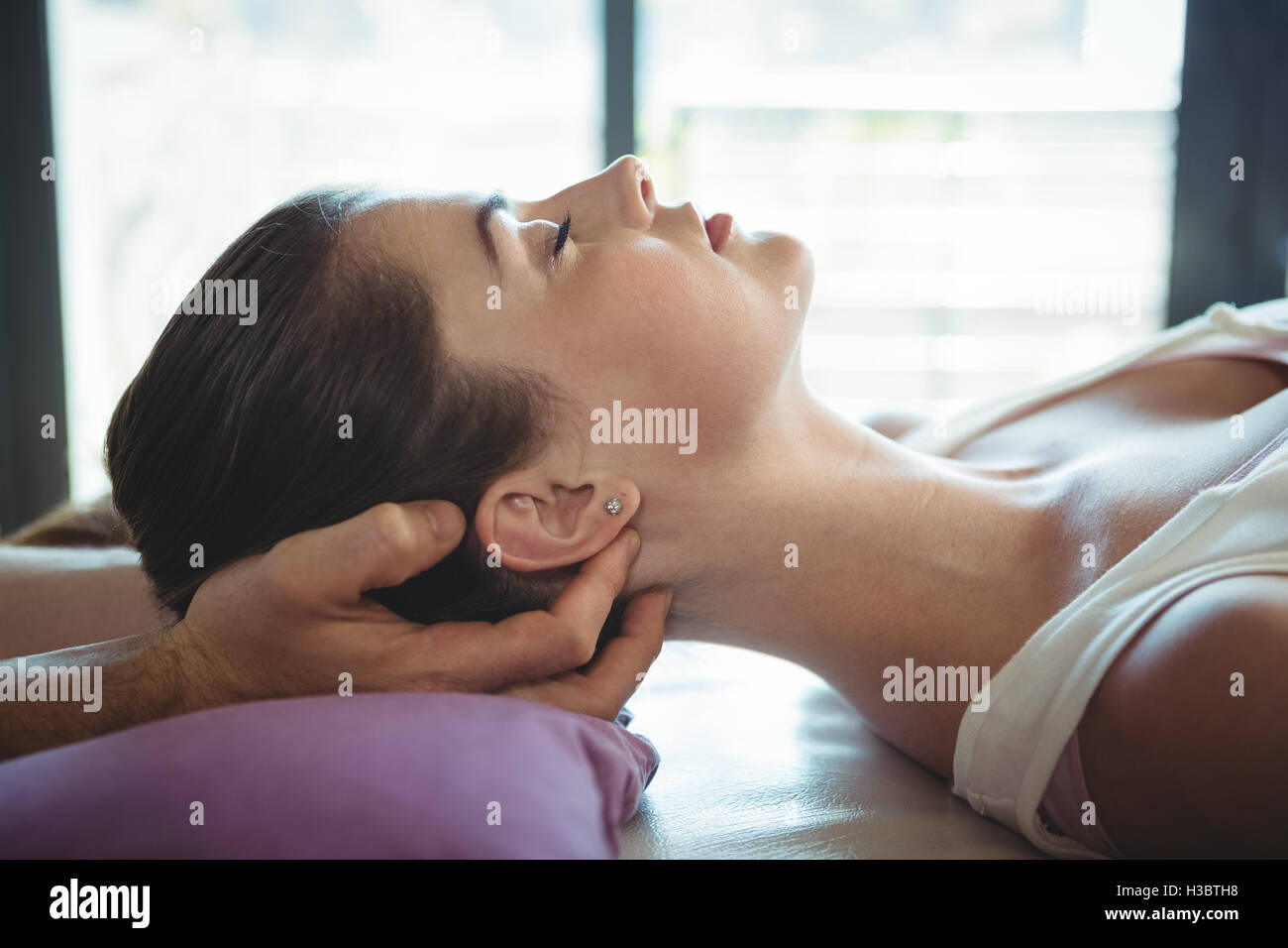 Männliche Physiotherapeut Patientin Kopfmassage verleihen Stockfoto