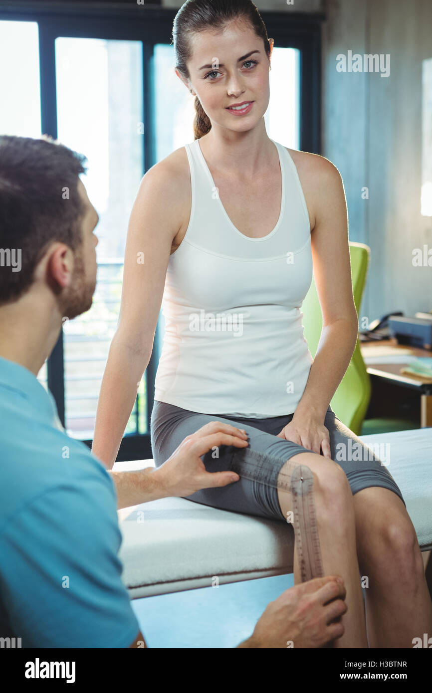 Männlichen Therapeuten Messung von weiblichen Patienten Knie mit Winkelmesser Stockfoto