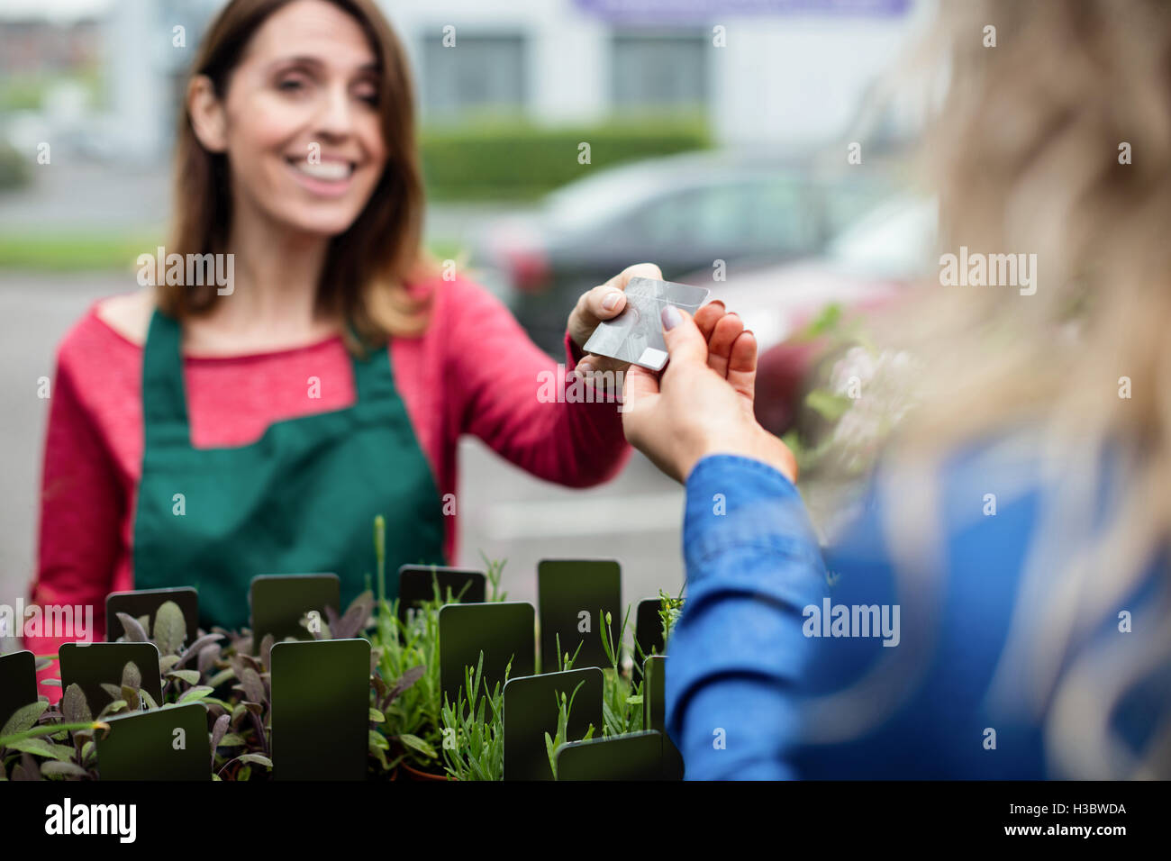 Frau, die die Zahlung mit ihrer Kreditkarte, florist Stockfoto