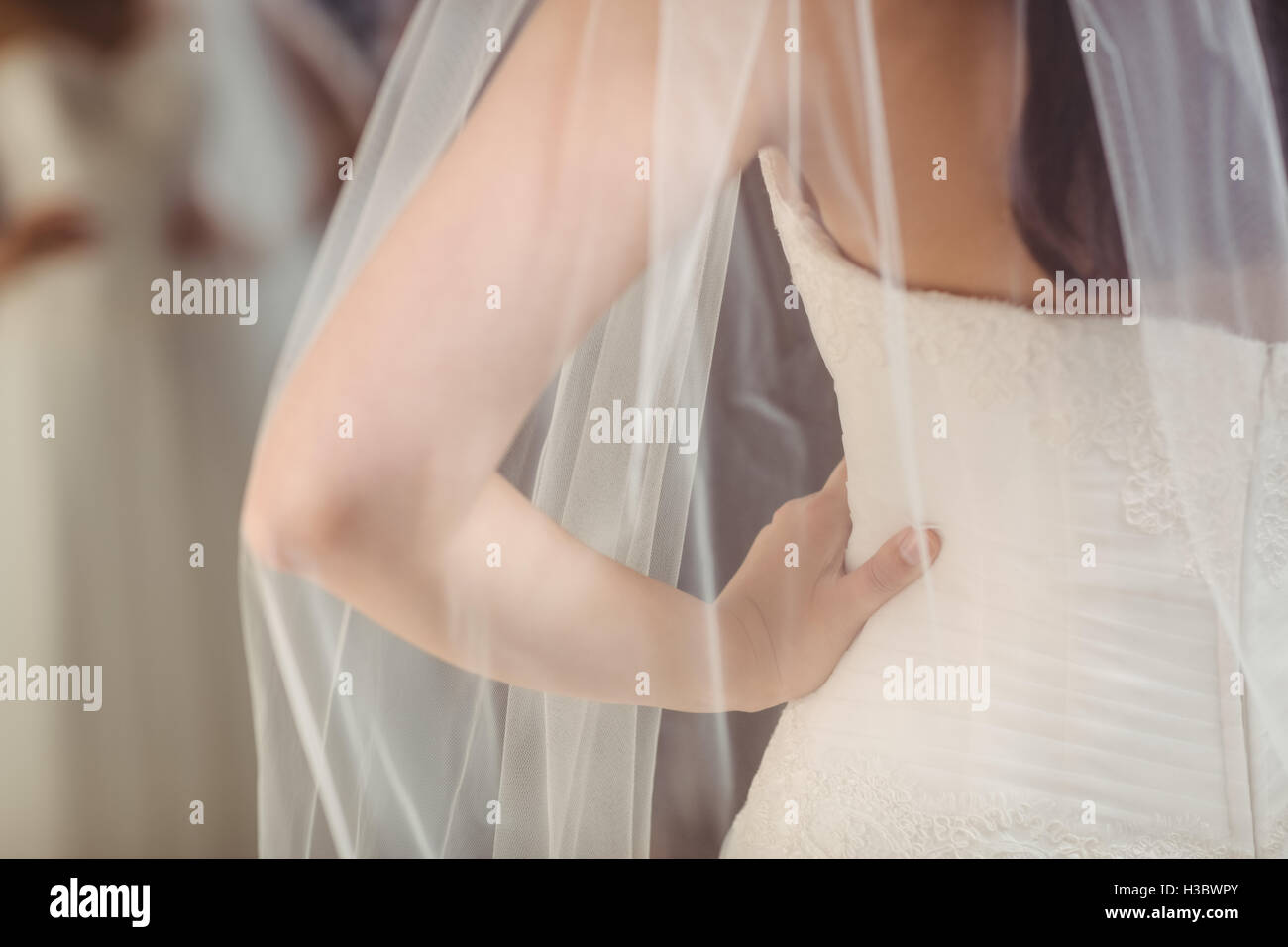 Frau versucht auf Hochzeitskleid in einem Geschäft Stockfoto