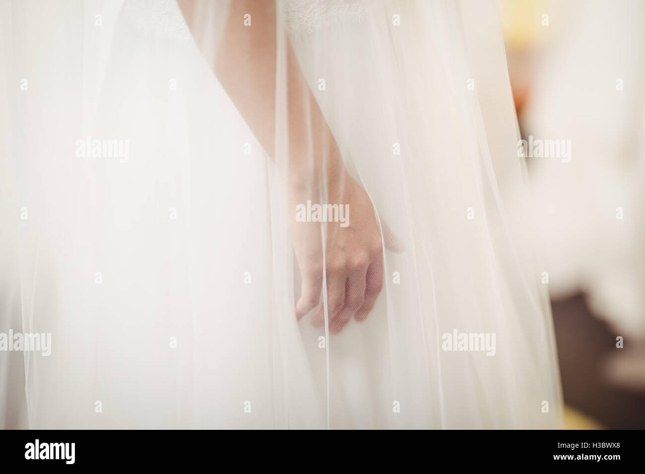 Frau versucht auf Hochzeitskleid in einem Geschäft Stockfoto