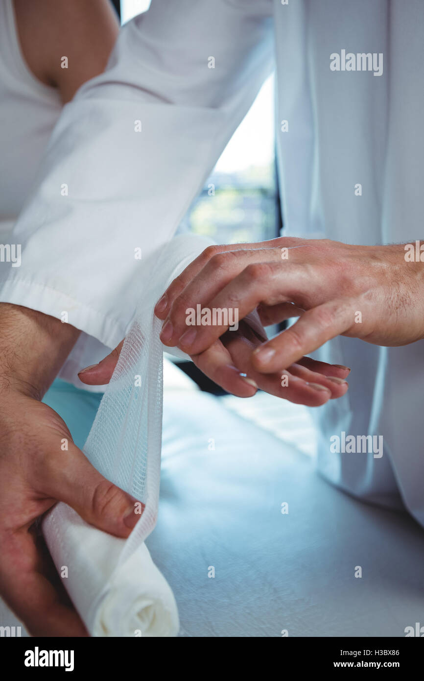 Männlichen Therapeuten weiblichen Patienten Hand Bandage anziehen Stockfoto