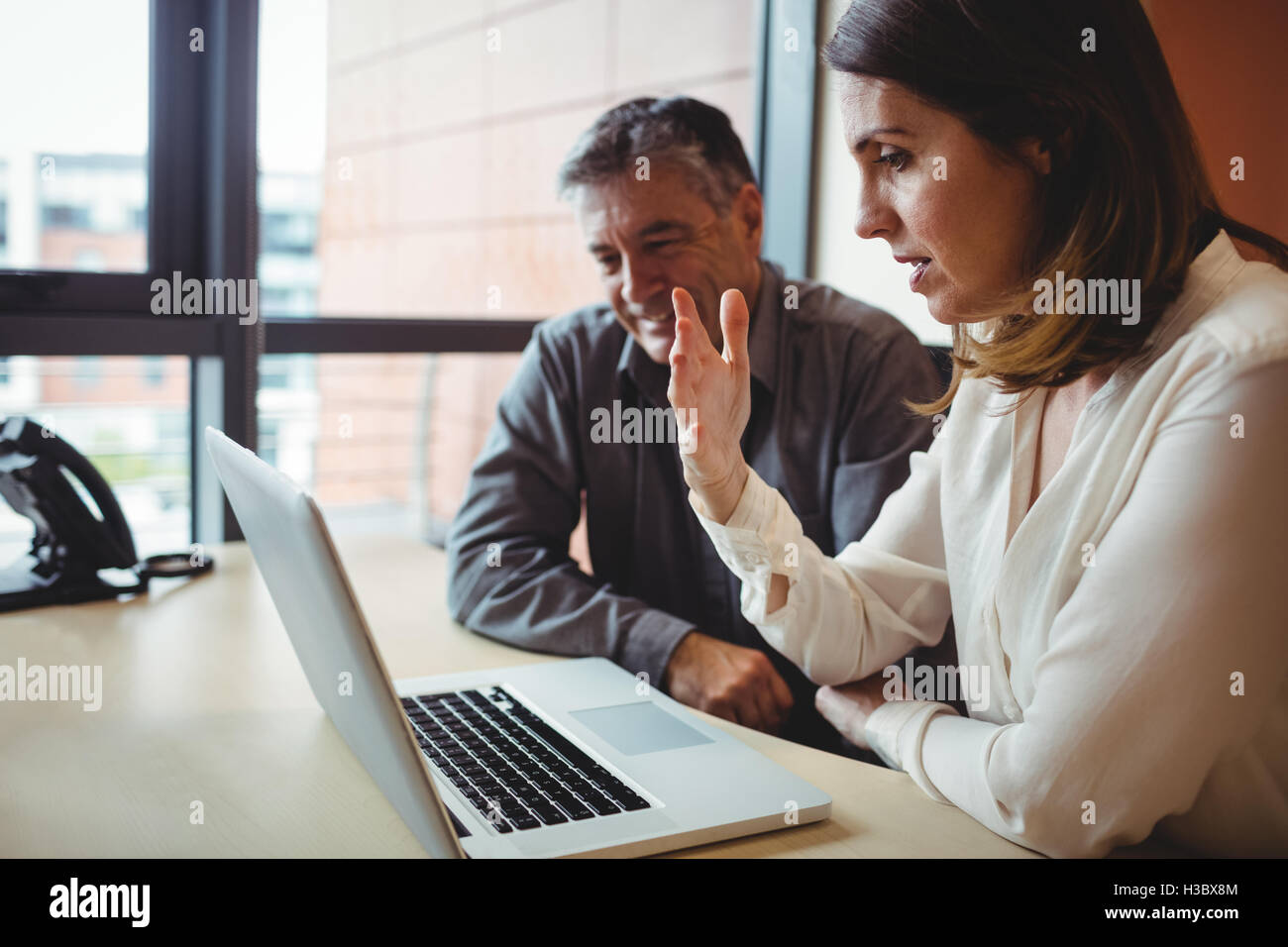 Mann mit Kollegen diskutieren über laptop Stockfoto