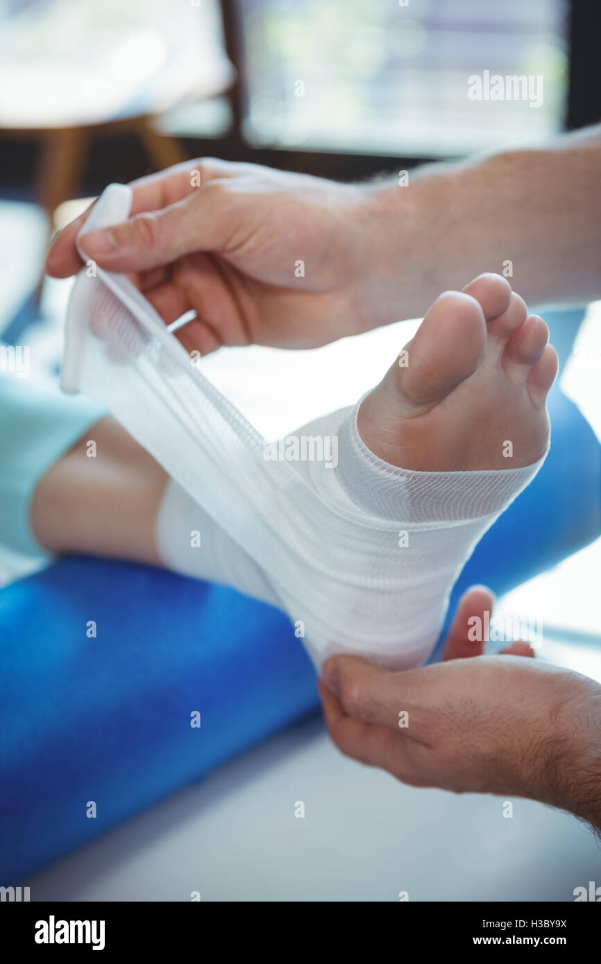 Männlichen Therapeuten weiblichen Patienten Fuß Bandage anziehen Stockfoto