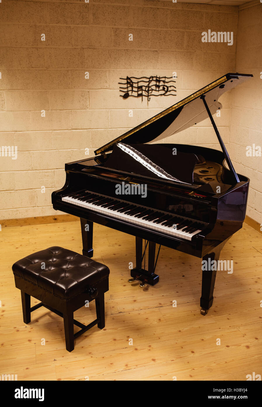 Klavier und Bank auf Holzboden Stockfoto