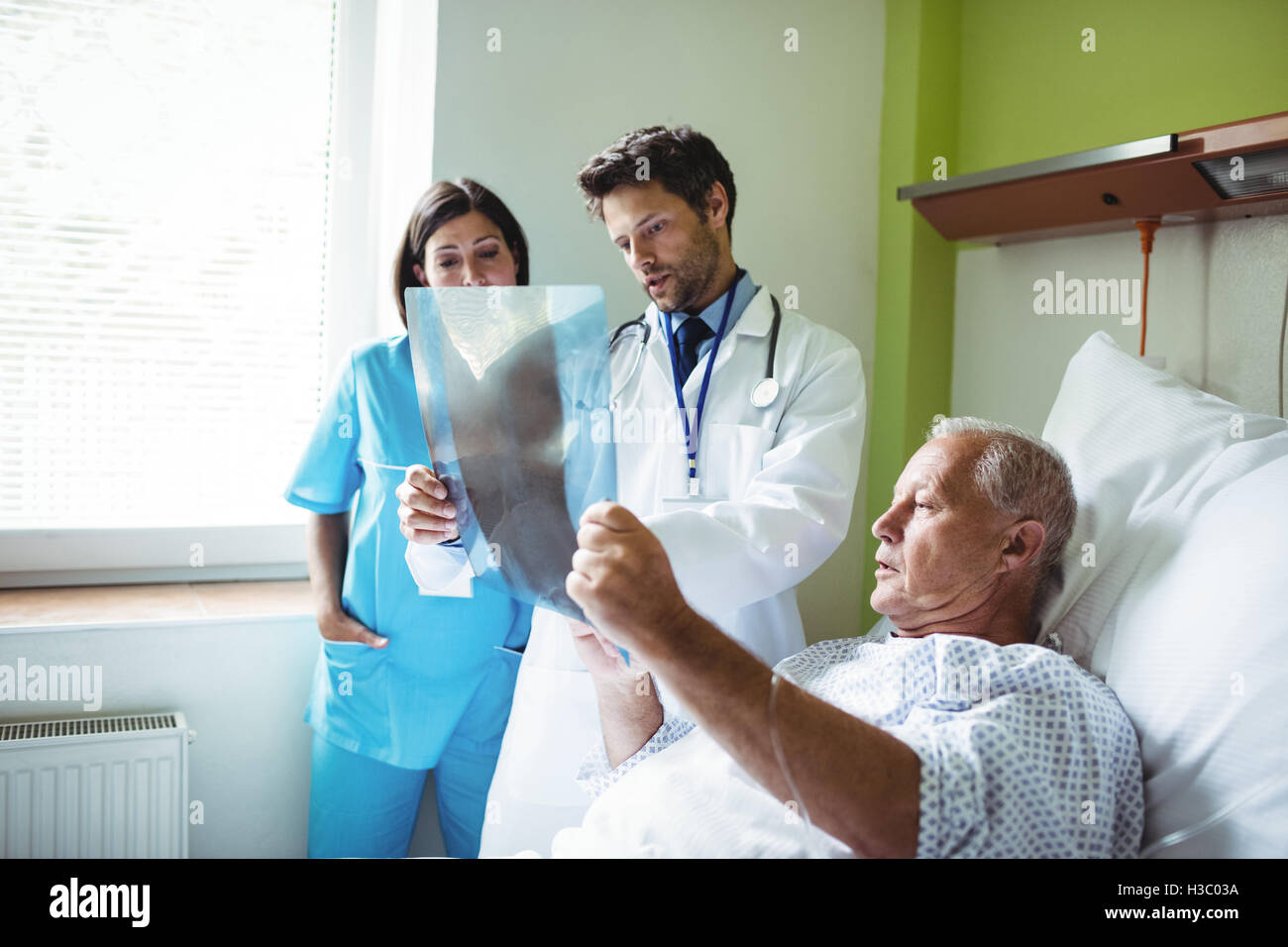 Arzt und Krankenschwester Interaktion über x-ray Bericht mit Patienten Stockfoto