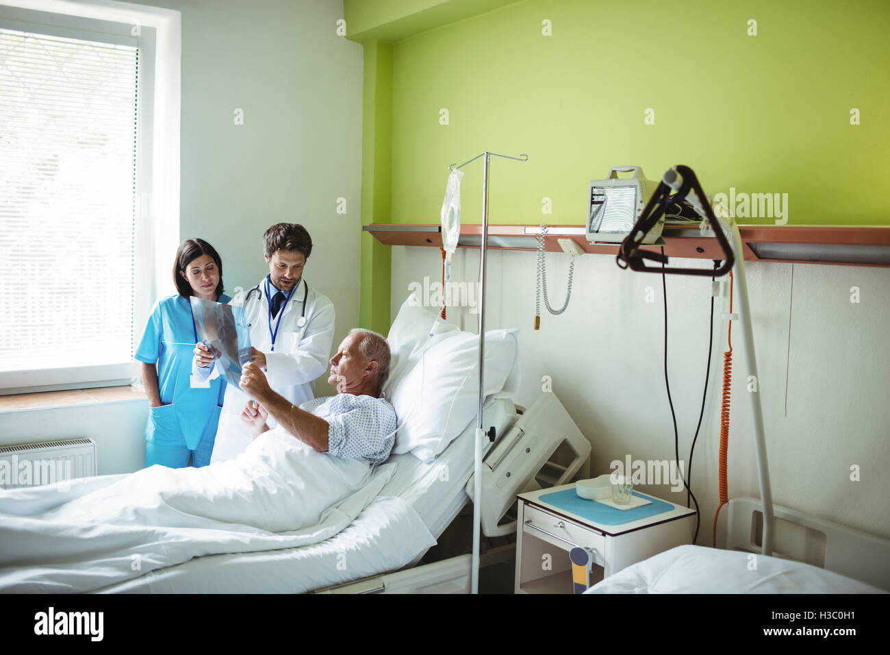 Arzt und Krankenschwester Interaktion über x-ray Bericht mit Patienten Stockfoto