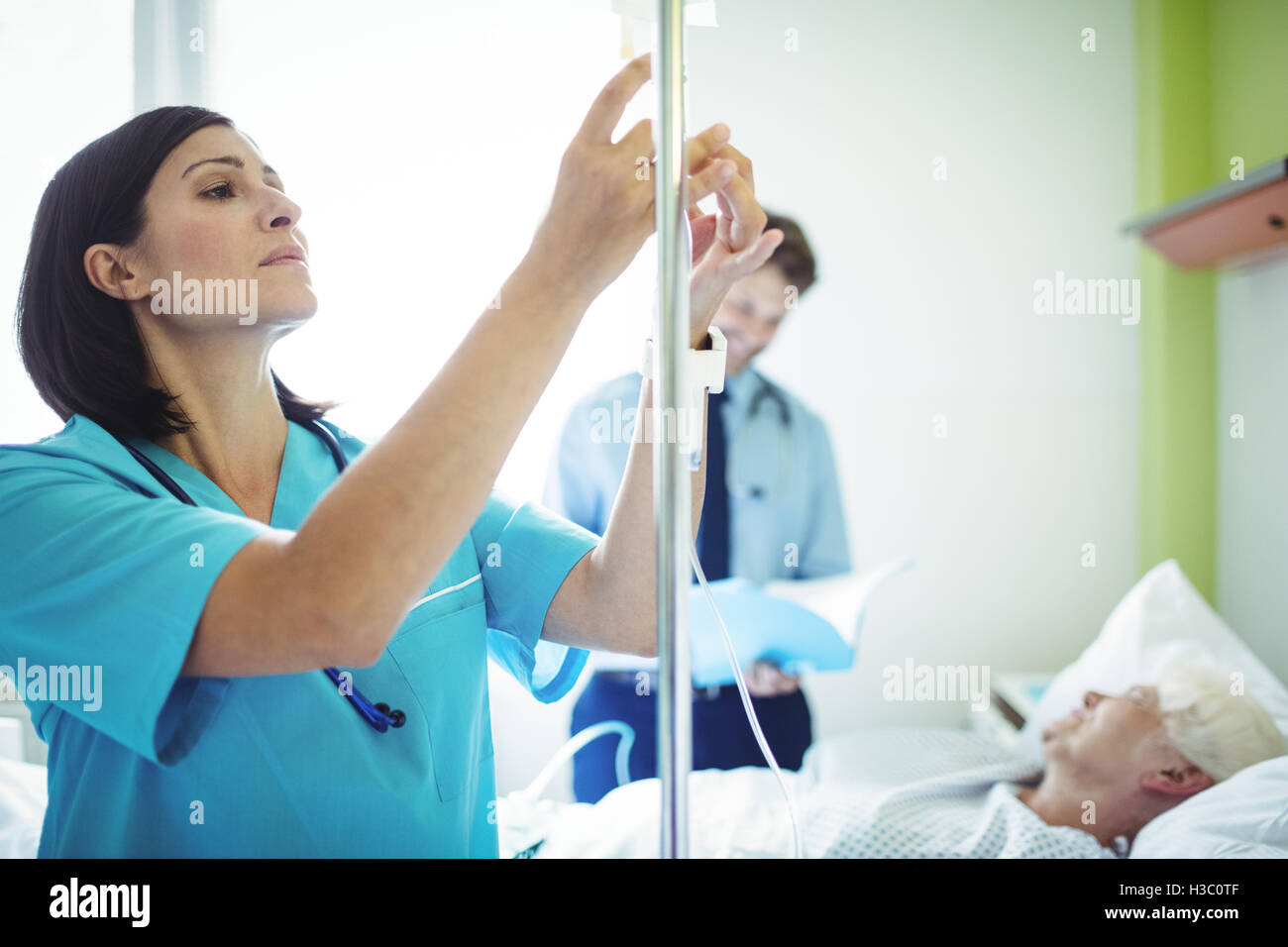 Krankenschwester, die Überprüfung eines Kochsalzlösung Tropf Stockfoto