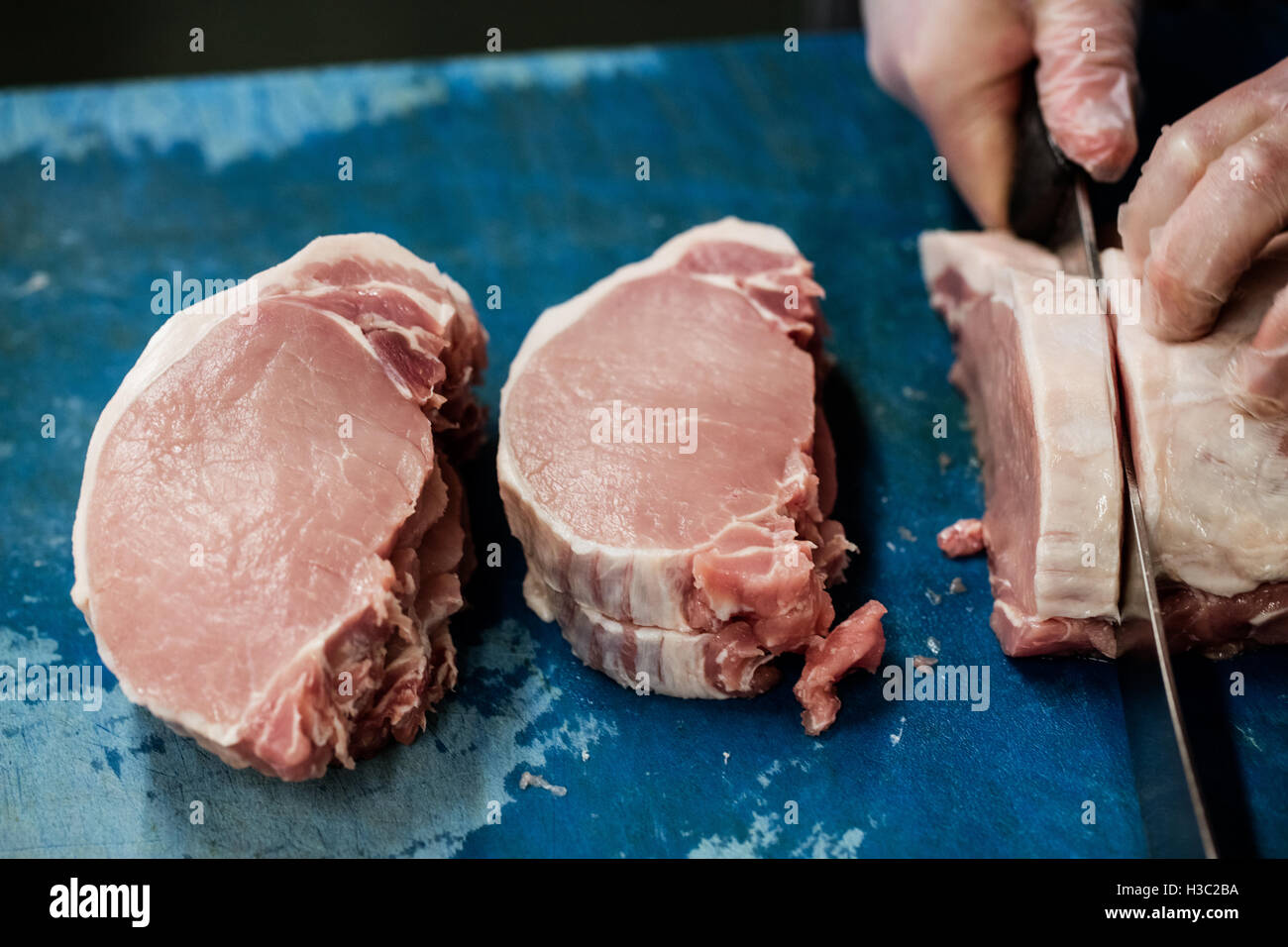 Hand der Metzger schneiden Fleisch Stockfoto
