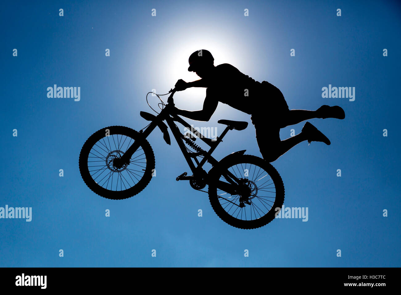 Ein extreme Fahrer macht einen freien Stil von einer Rampe springen. Der junge mit seinem Fahrrad gilt als Silhouette vor der Stockfoto