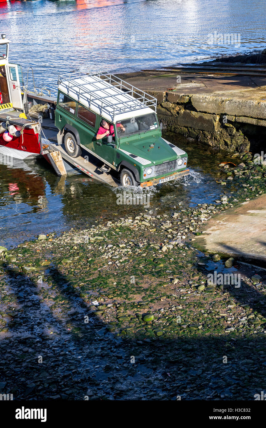 Hafenarbeiter entladen ein Landrover 110 County von einem kleinen Landungsboote am Hafen von Mallaig, Schottisches Hochland. Stockfoto