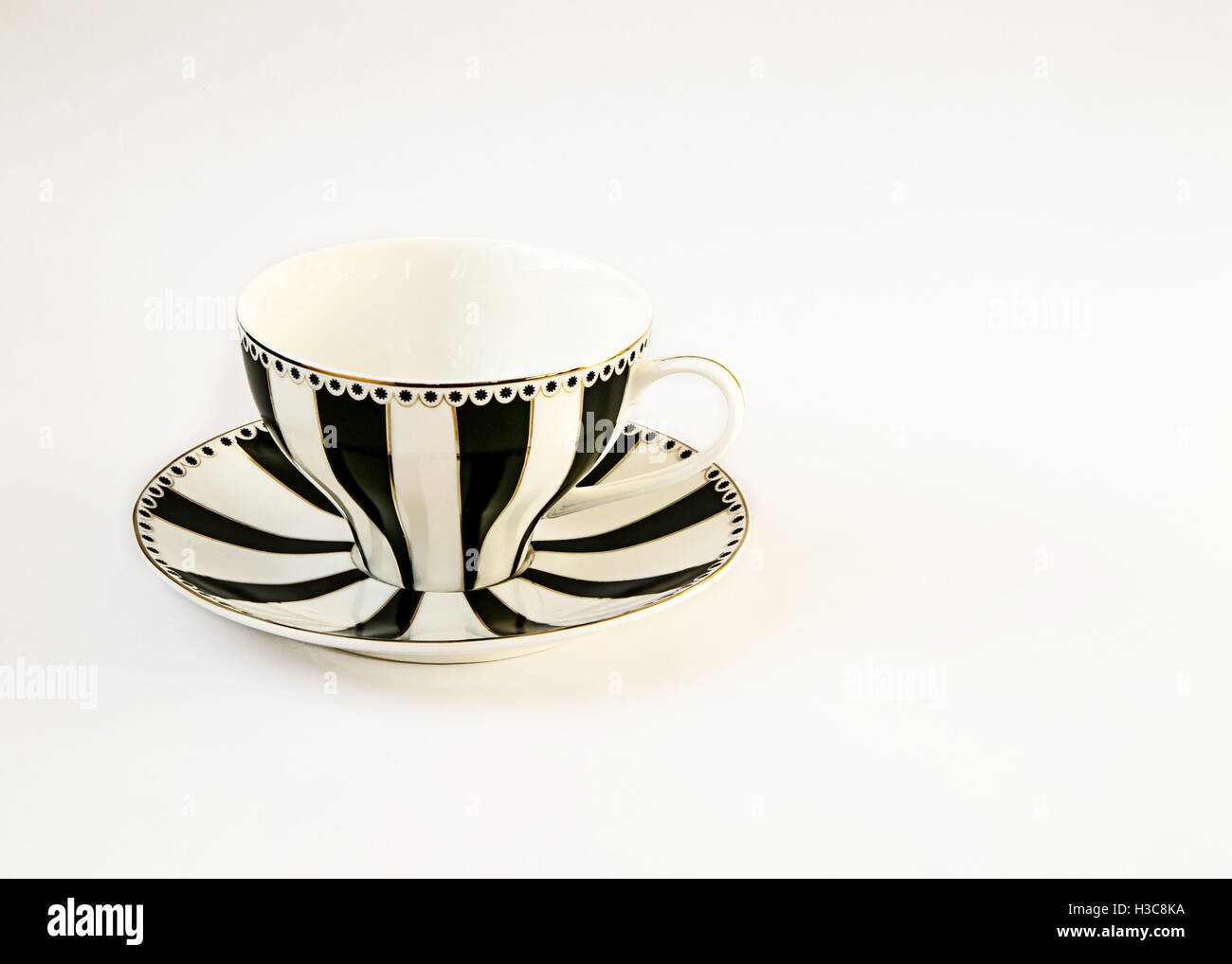 Schöne schwarz / weiß gestreift-Tasse und Untertasse isoliert auf weiss. Stockfoto