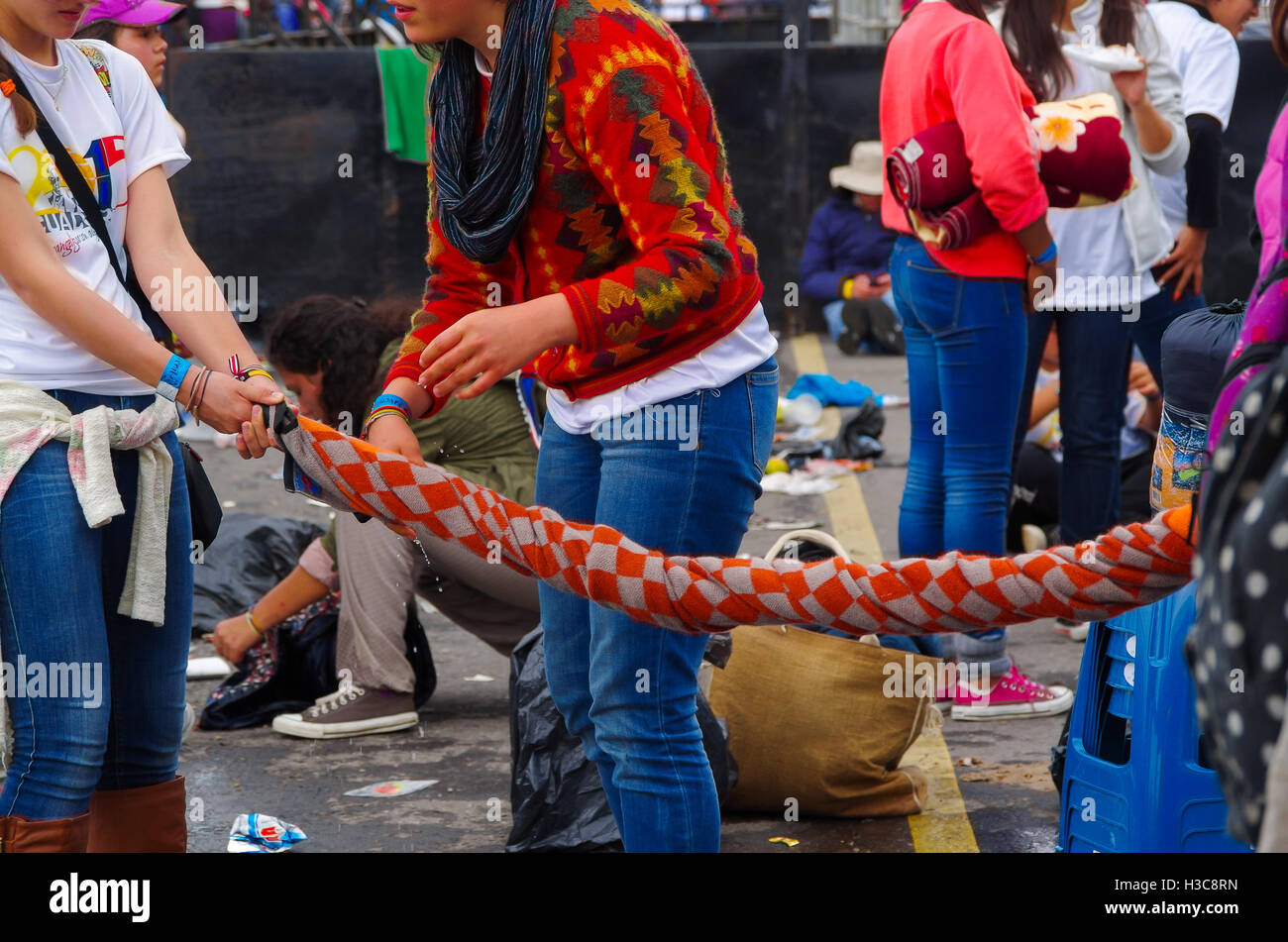 QUITO, ECUADOR - 7. Juli 2015: Zwei Womans machen einige Twist mit ihrer Decke, wegen des Regens auswringen Stockfoto