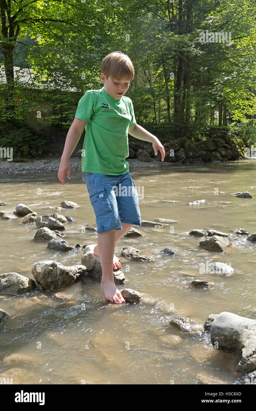 Junge zu Fuß durch den Fluss, See Staufen, Guetle, Dornbirn, Vorarlberg, Österreich Stockfoto