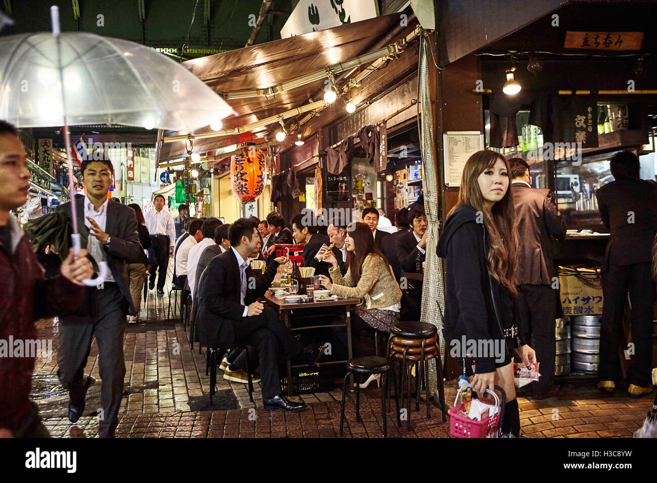 Tokio, Japan, Oktober 2011. Männer in schwarzen Büro Anzügen sitzen im Café im freien nach der Arbeit in Tokio - Ueno Bahnhofsbereich Stockfoto