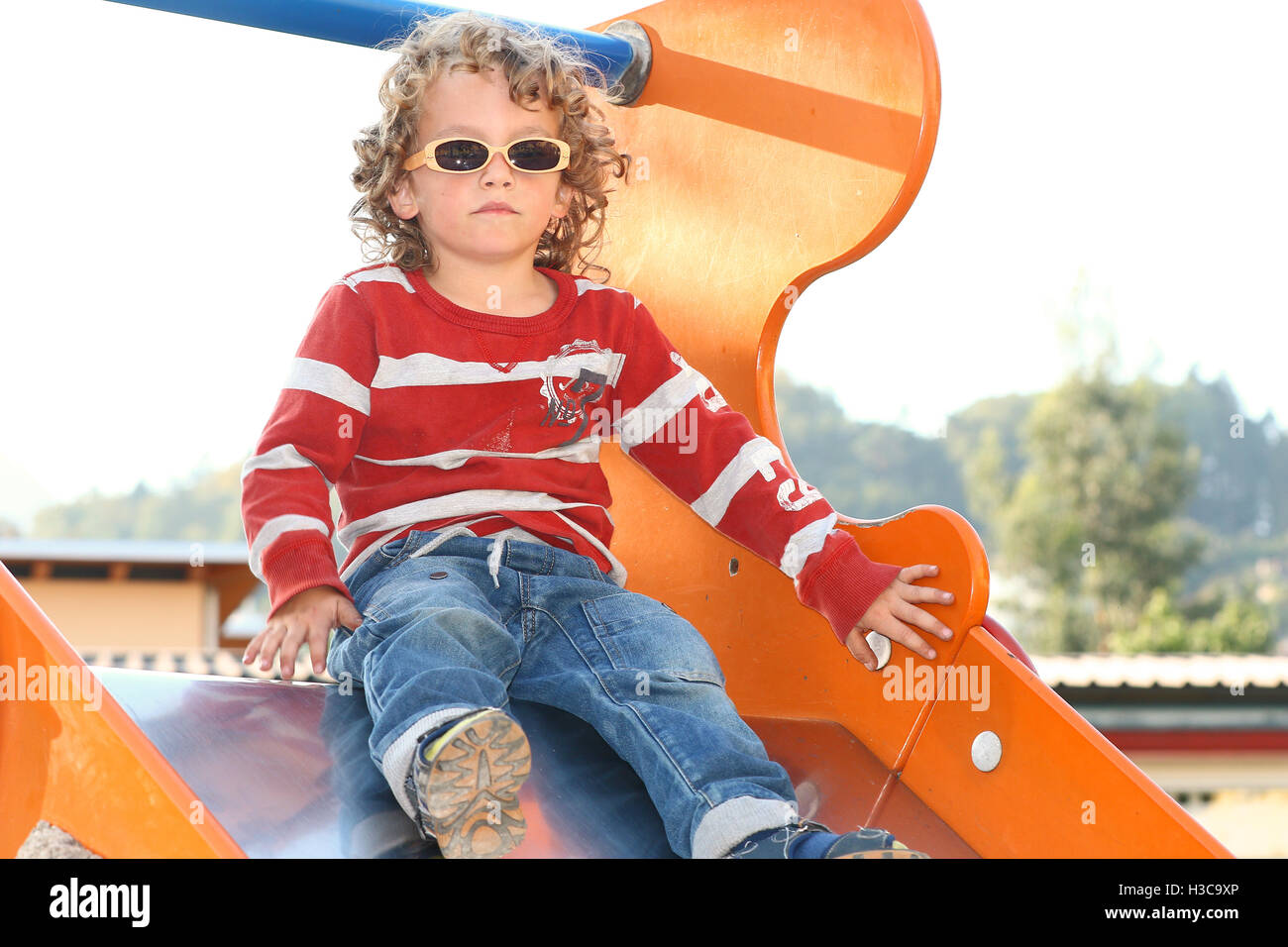 Blonden lockigen Haaren Kind mit Sonnenbrille auf dem Spielplatz spielen Stockfoto