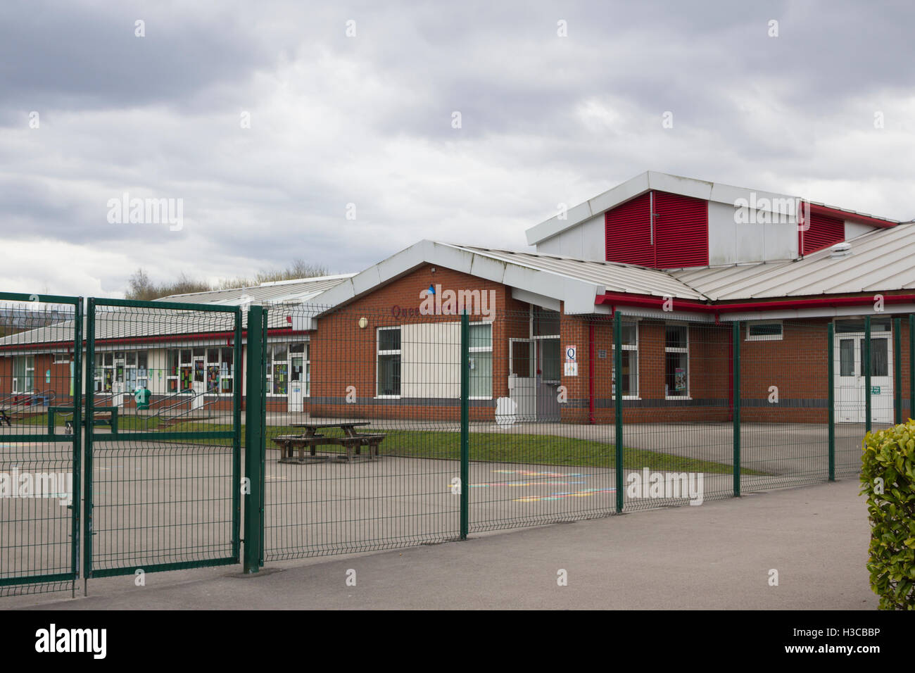 Hochseil-Sicherheitszaun umgibt den Spielplatz in Queensbridge Grundschule, St. Germain Street, Farnworth. Stockfoto