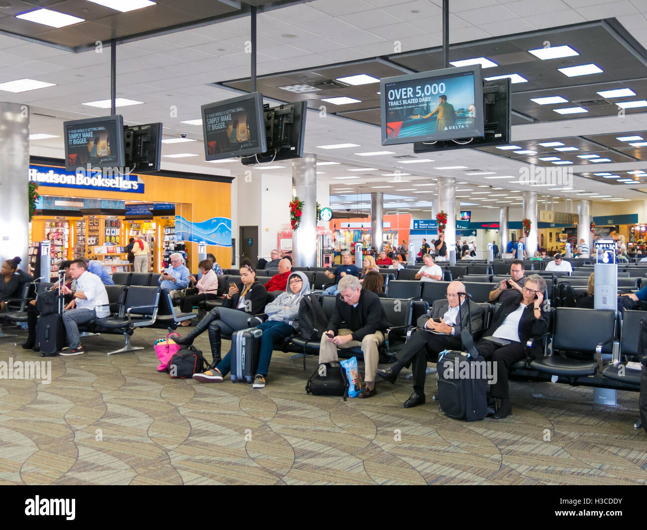Menschen sitzen und warten auf Fort Lauderdale Hollywood International Airport in Florida, USA Stockfoto