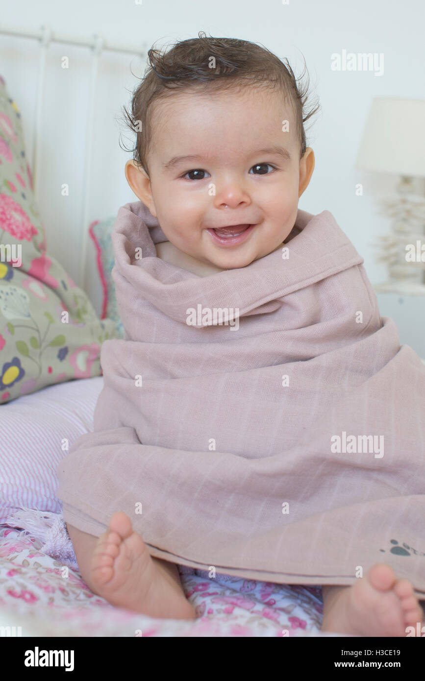 Baby in ein Handtuch gewickelt, Lächeln, Porträt Stockfoto