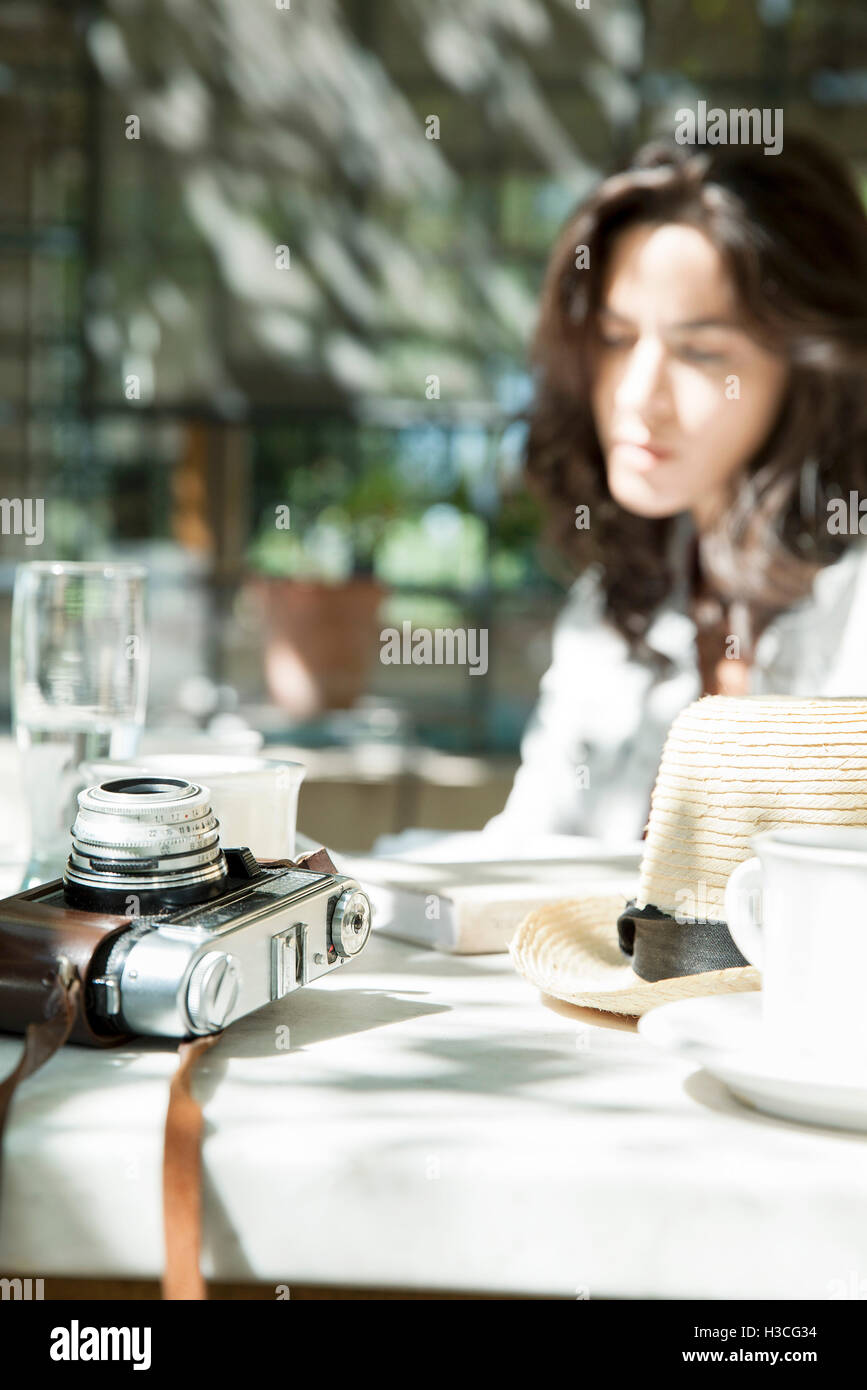 Kamera und Tasse und Untertasse auf Tisch im freien Stockfoto